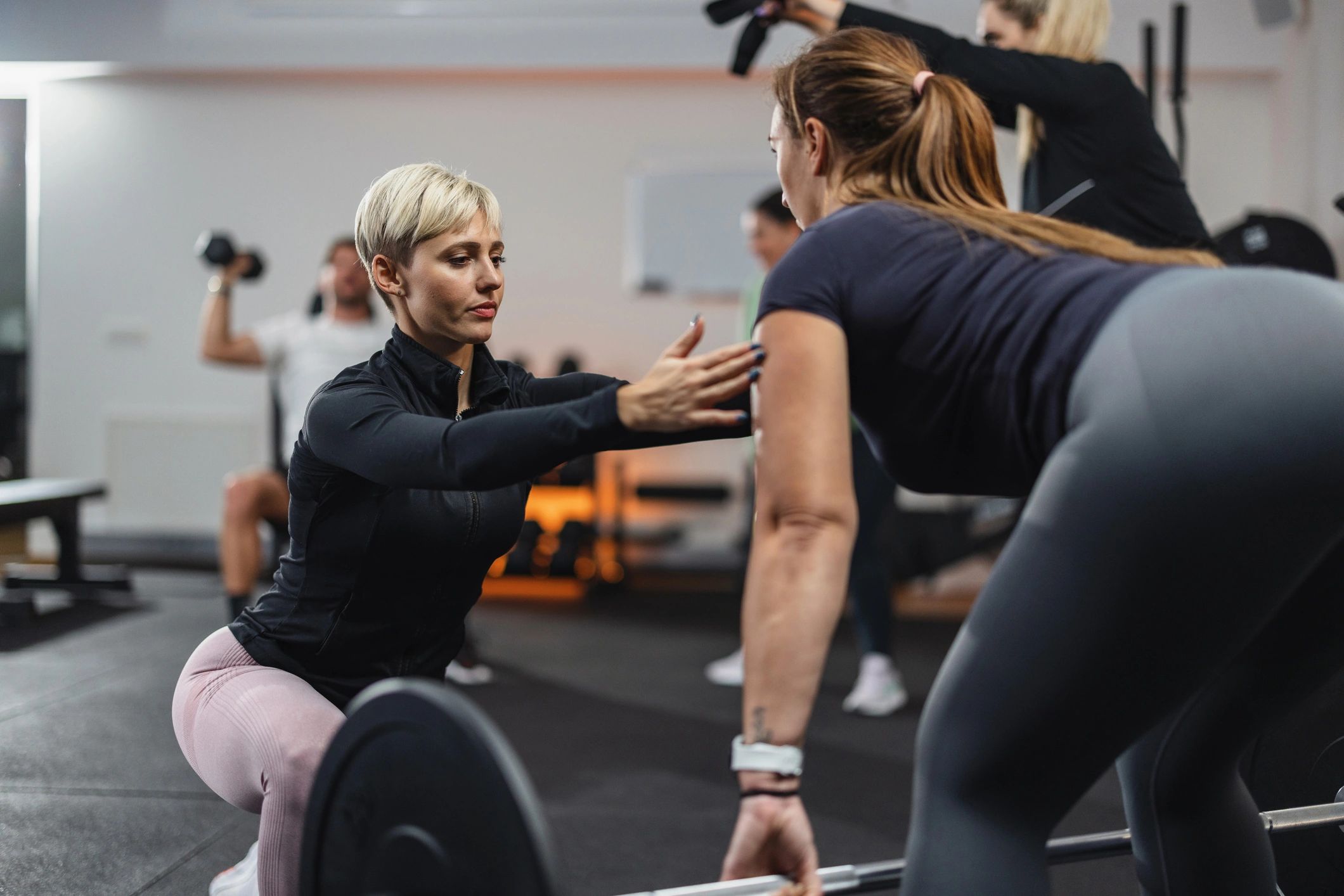 Personal trainer coaching a client during a strength exercise